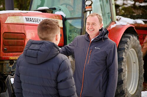 Tim stood by a tractor