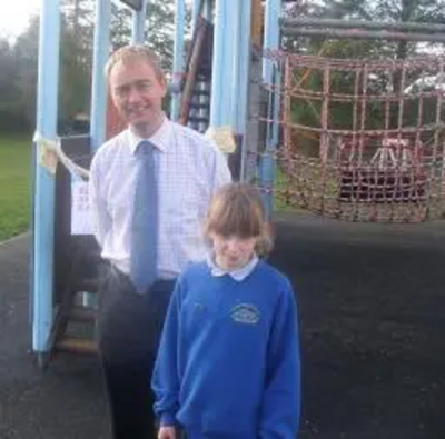 Tim by the condemned climbing frame at Crosscrake School with a pupil