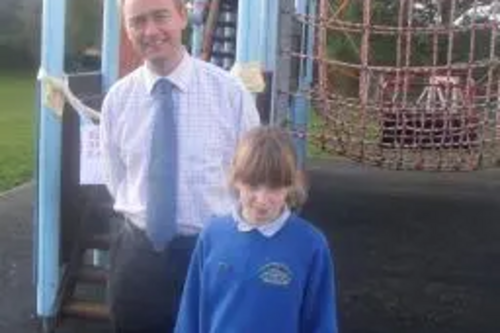 Tim by the condemned climbing frame at Crosscrake School with a pupil