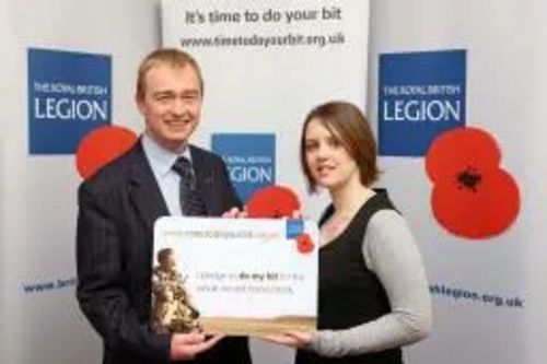 Tim Farron is pictured being presented by Legion staff member, Bethan Herbert, with a giant replica of the personalised pledge card which he has been given in recognition of his pledge.