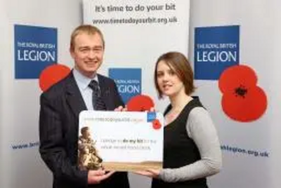 Tim Farron is pictured being presented by Legion staff member, Bethan Herbert, with a giant replica of the personalised pledge card which he has been given in recognition of his pledge.